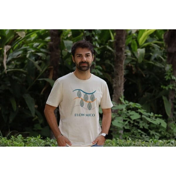 Hombre con Camiseta Future Green de Flow Mico en color crudo con manos en bolsillos en entorno natural