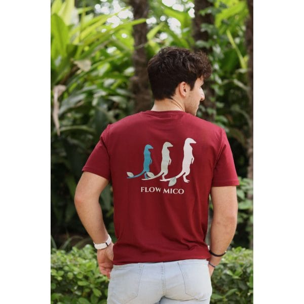 Vista trasera de hombre con Camiseta Burgundy Savannah mostrando la ilustración de tres suricatos y texto Flow Mico