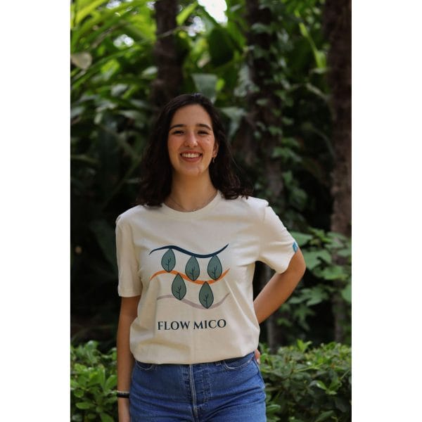 Mujer sonriendo con Camiseta Future Green de Flow Mico en color crudo con ilustración de hojas y texto Flow Mico