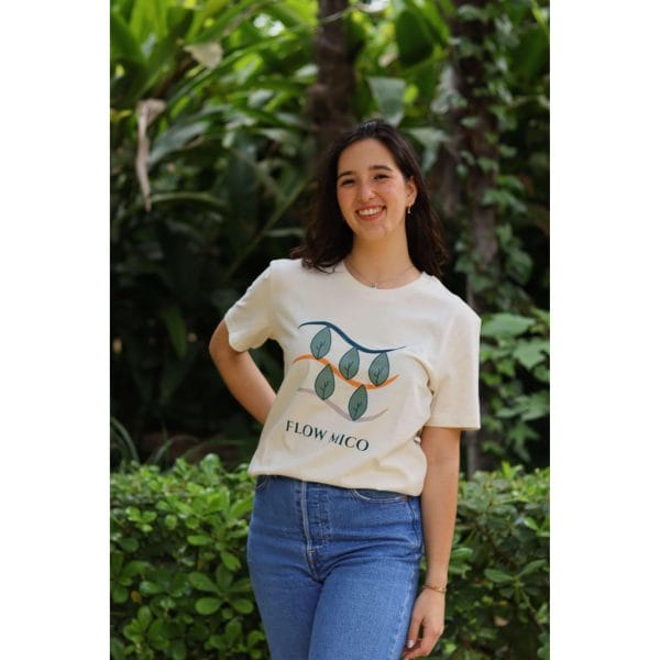 Mujer sonriendo con Camiseta Future Green de Flow Mico en color crudo con ilustración de hojas y texto Flow Mico visible