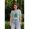 Mujer sonriendo con Camiseta Positano de Flow Mico en verde salvia con logo Flow Mico visible en entorno natural
