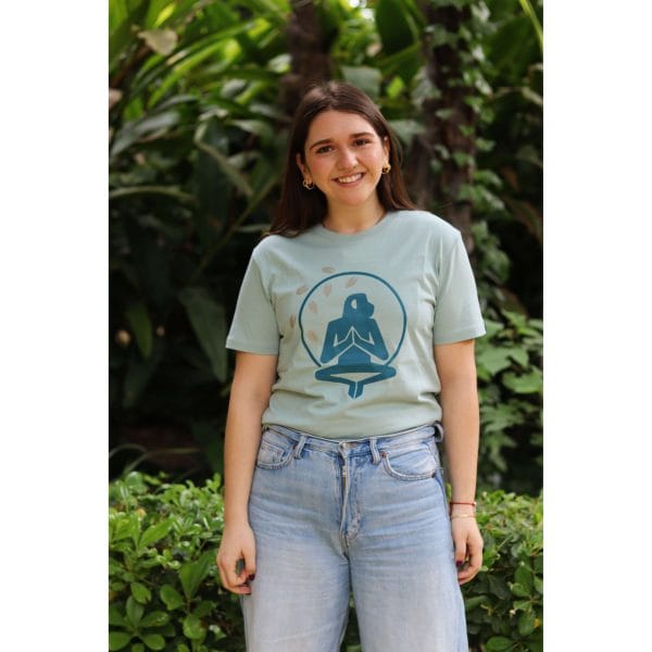 Mujer sonriendo con Camiseta Positano de Flow Mico en verde salvia con logo Flow Mico visible en entorno natural