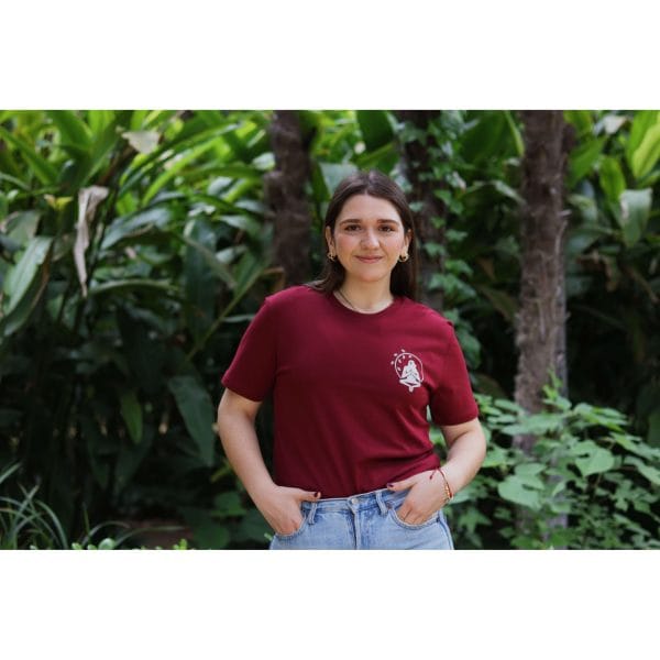 Mujer sonriendo con Camiseta Burgundy Savannah de Flow Mico en color burdeos con logo en pecho