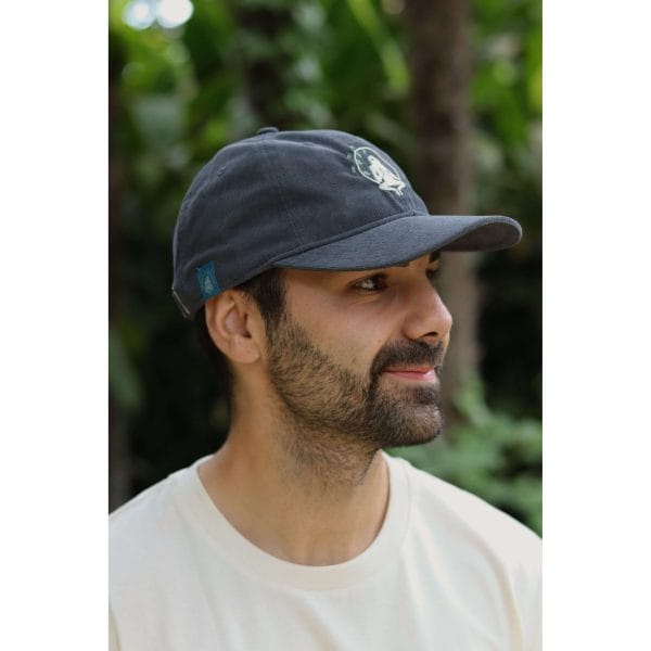 gorra-yosemite-blue-hombre-perfil Vista lateral de hombre con Gorra Yosemite Blue de Flow Mico mostrando la etiqueta azul turquesa