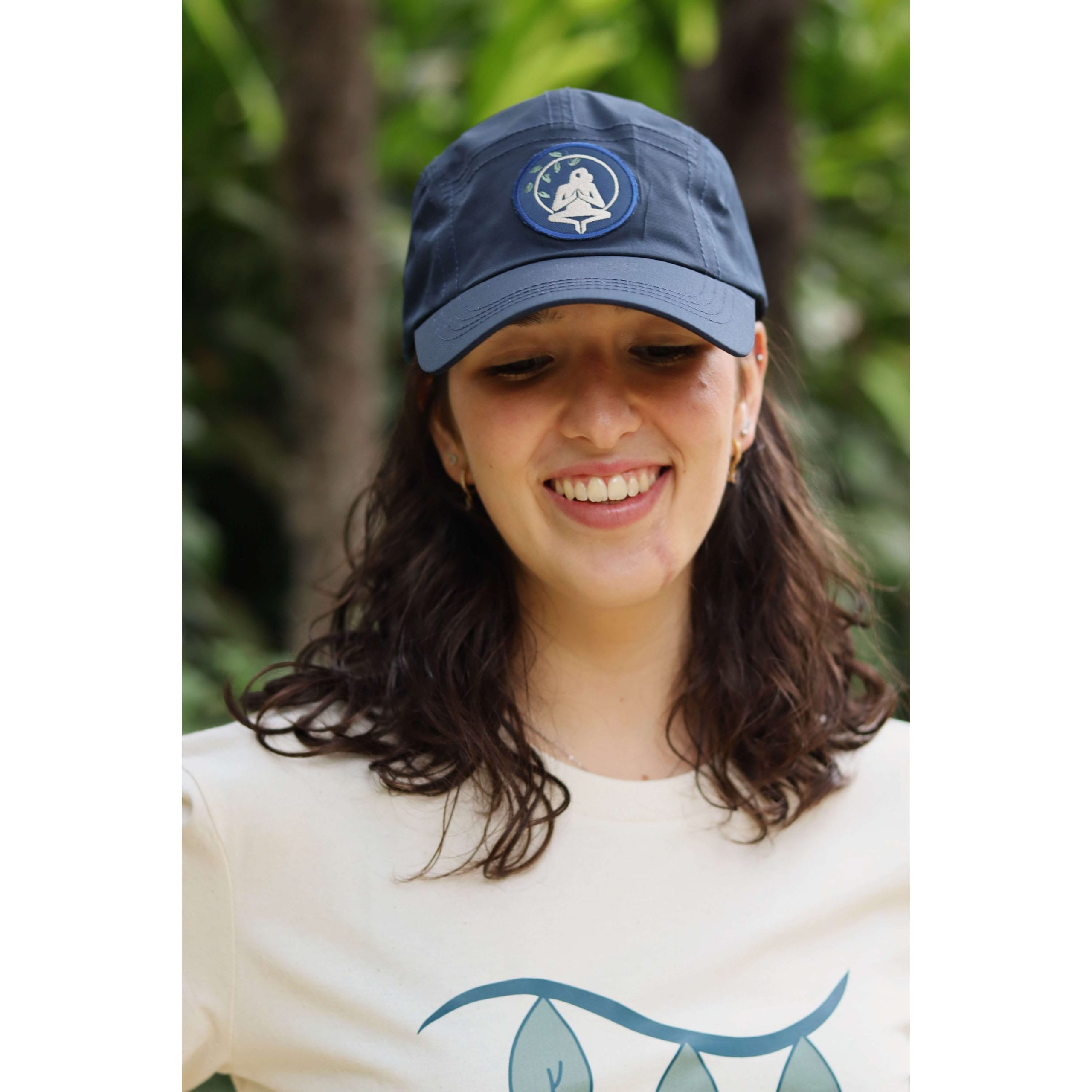 Gorra Yosemite Blue impermeable de material reciclado en azul navy con logo Flow Mico, puesta en entorno natural