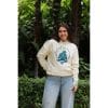 sudadera-natural-zen-mujer-frontal-3 Mujer sonriendo con Sudadera Natural Zen de Flow Mico en color crudo con logo de meditación grande en el pecho