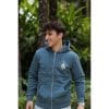 sudadera-balance-haven-hombre-lateral-2 Hombre sonriendo mirando a un lado con Sudadera Balance Haven de Flow Mico en azul petróleo en entorno natural