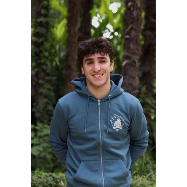 sudadera-balance-haven-hombre-frontal Hombre sonriendo con Sudadera Balance Haven de Flow Mico en azul petróleo con logo Flow Mico bordado visible