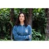 sudadera-balance-haven-mujer-frontal Mujer con Sudadera Balance Haven de Flow Mico en azul petróleo con cremallera y brazos cruzados en entorno natural