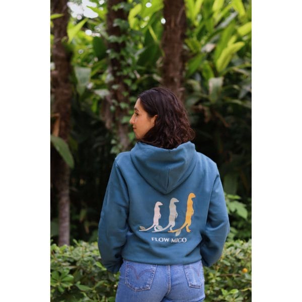 sudadera-balance-haven-mujer-trasera Vista trasera de mujer con Sudadera Balance Haven mostrando la ilustración de tres suricatos y texto Flow Mico